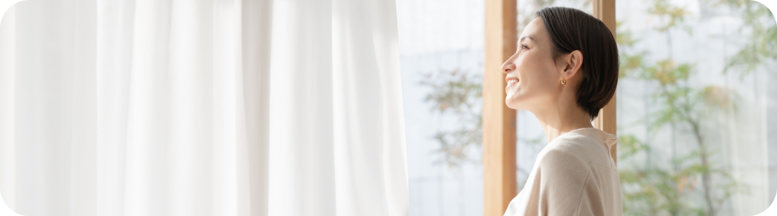 窓から外を見る女性の写真